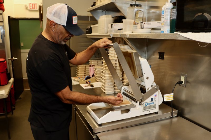 Maris Leftwich seals up meals in the kitchen at Fish On, the SoDel Concepts restaurant at Five Points where all of the Meals on Wheels dishes are prepared. SoDel employees do all the cooking, starting at 5 a.m., Monday through Friday.